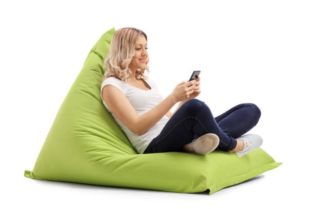 istock Woman texting on phone seated on beanbag 522132580