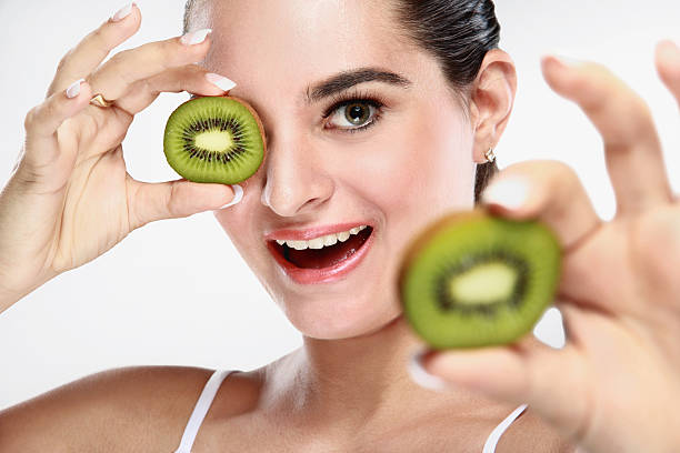 istock cheerful beautiful young woman with kiwi fruit in her hands 522133976