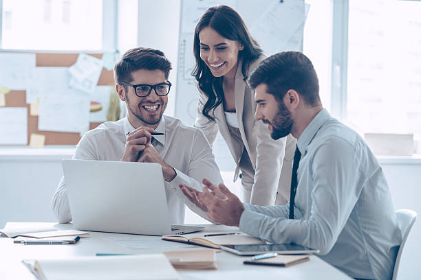 Great business meeting. Three coworkers discussing something with smile while sitting at the office necktie photos stock pictures, royalty-free photos & images