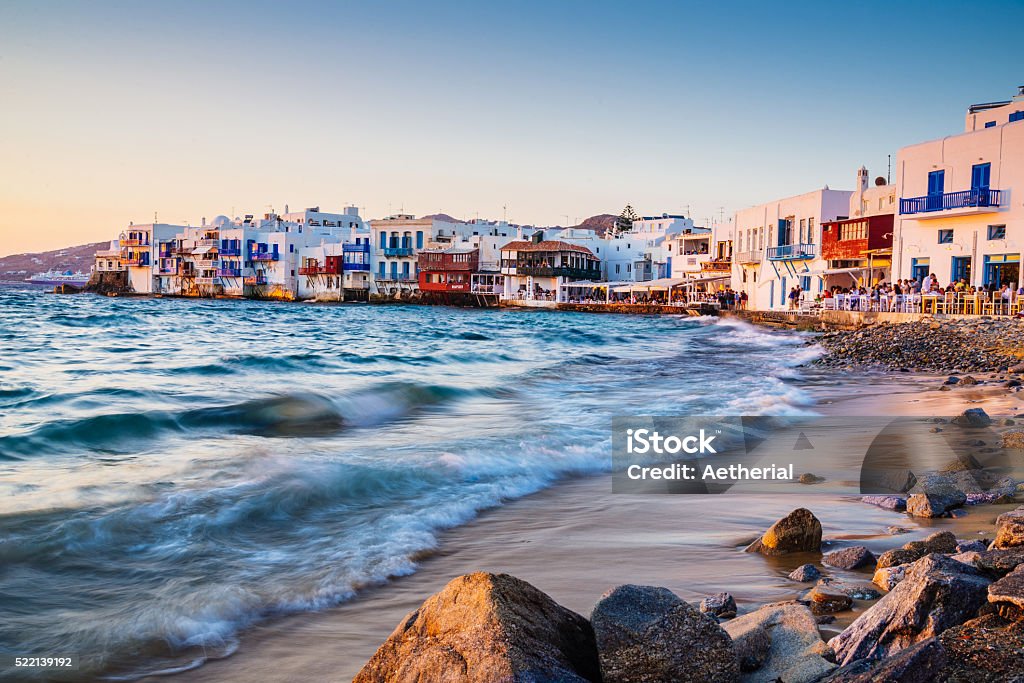 Sunset at Mykonos Little Venice Rolling waves and sunset dining at famous Mykonos neighborhood of Little Venice, Mykonos, Greece Mediterranean Sea Stock Photo