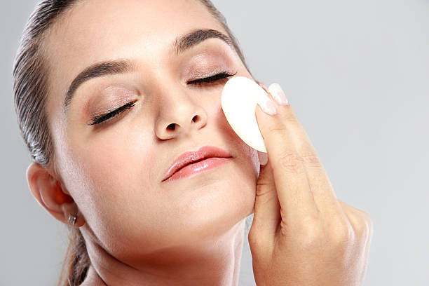 istock woman smiling while applying powder puff 522140250