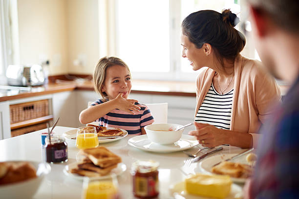 la prima colazione è di meglio con la famiglia - little girls small eating breakfast foto e immagini stock