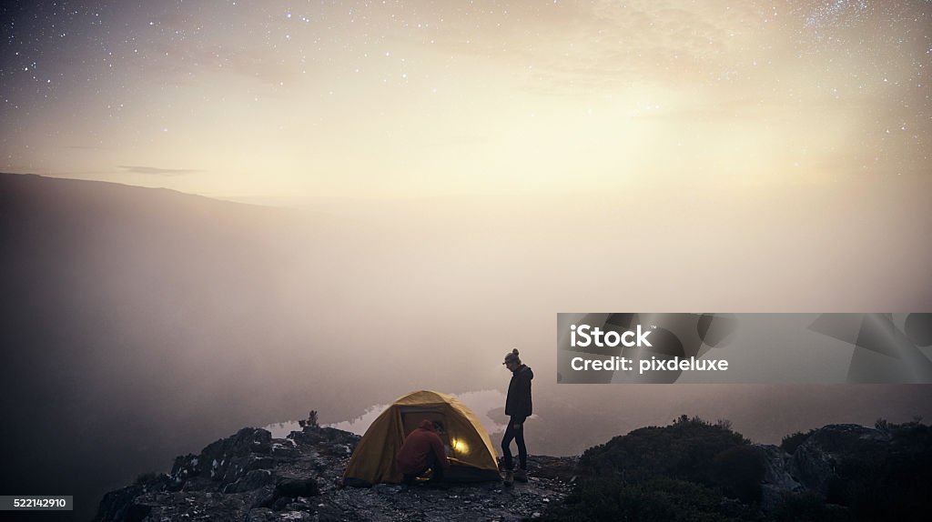 Together is the best place to be Shot of a young couple camping on top of a mountain 20-29 Years Stock Photo