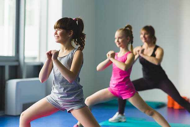 Girls and Instructor or mother doing gymnastic exercises  in fitness stock photo