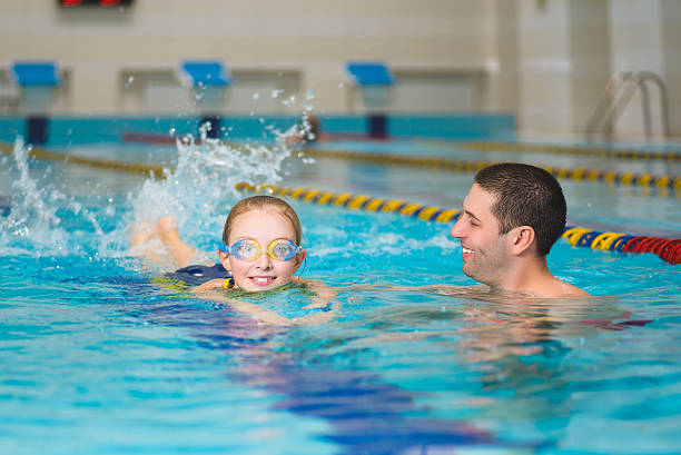 istock instructor teaches the girl swimming in a pool 522149318