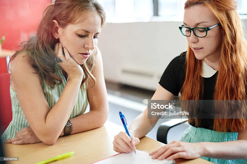 Unposed group of creative business people in an open concept Candid picture of a business team collaborating. Filtered serie with light flares and cool tones. Teacher Stock Photo