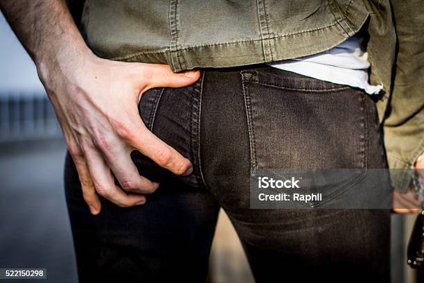 Groping Hand Grabs Womans Butt In Public And Harassing Her Stock Photo - Download Image Now