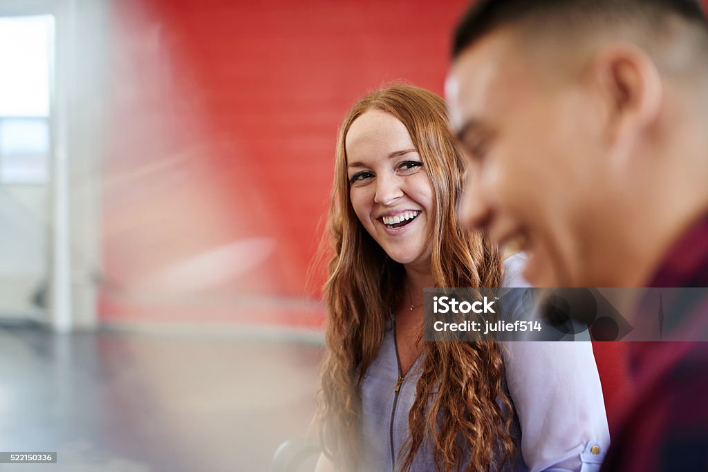 Unposed group of creative business people in an open concept Candid picture of a business team collaborating. Filtered serie with light flares and cool tones. Candid Stock Photo