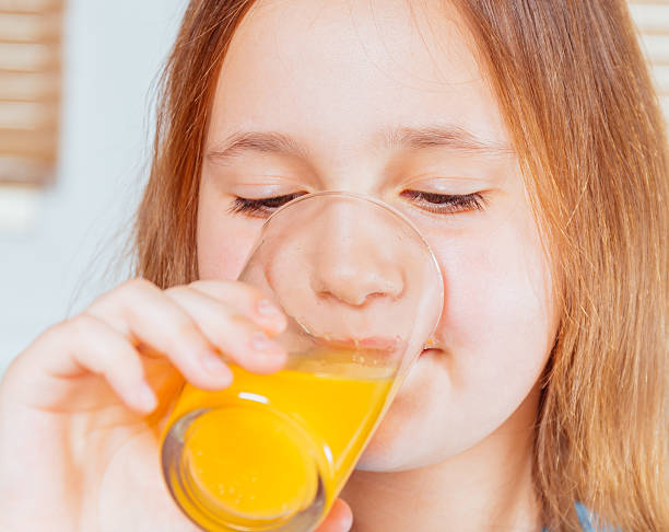 istock Child is drinking orange juice 522150533