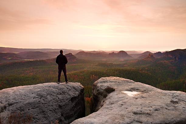 istock Hiker on cliff in rocky empires park, watching over mist 522150724