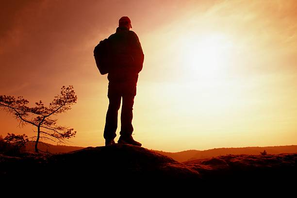 istock Tourist with backpack on cliff, watching to Sun. Sunny spring 522150822
