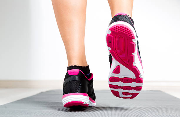 Close up of woman feet running on exercising mat.