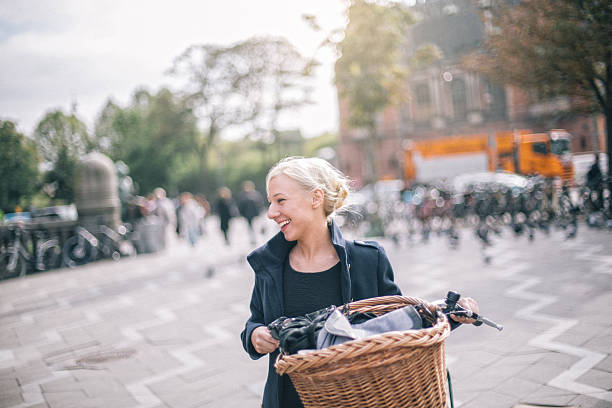 Young woman enjoying bicycle riding, while finishing her chores in the city