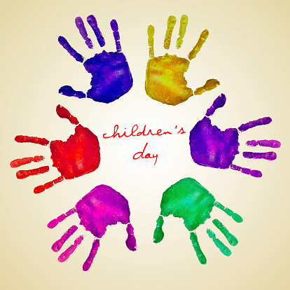 handprints of different colors forming a circle and the text childrens day written in the center on a beige background