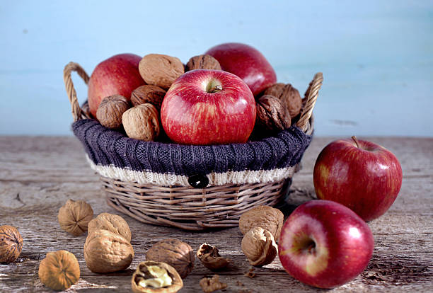 istock Basket full of red apples and walnuts in shells, autumn 522154047