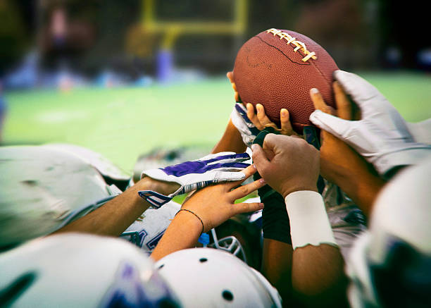 American football balls, rugby balls, different colours on grass and black backgrounds. High quality photo