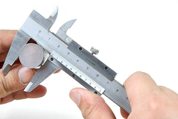 A focused close-up shot shows an artisan carefully measuring a small jewelry piece using a precision caliper.