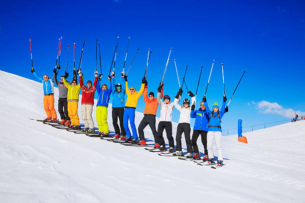 Ski club school skiing trips   Colorful group of snow skiers A large happy group of snow skiers. Ski club school skiing trips. Friends - Colorful male and female groups, enjoying on sunny ski resorts.  The snow in the foreground, beautiful blue sky in the background, applicable for all ski resorts and locations.  Shot with Canon 5DMarkIII, developed from RAW, Adobe RGB color profile.  dolomite photos stock pictures, royalty-free photos & images