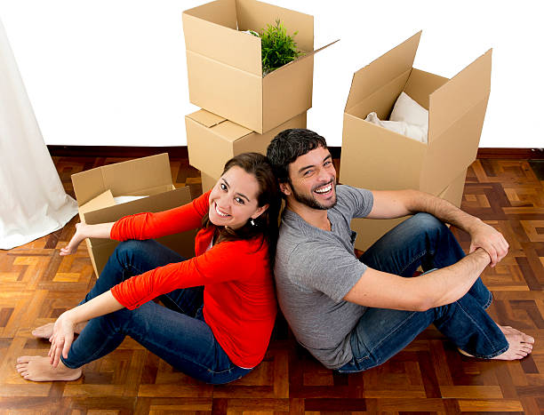 casal feliz no novo apartamento em movimento desempacotar caixas de cartão - for rent sign house sign happiness imagens e fotografias de stock