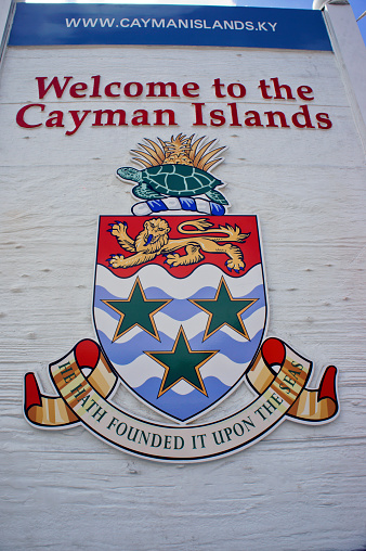 George Town, Cayman Islands - January 26, 2013: The Cayman Islands’ coat of arms welcomes tourists and visitors in the cruise ships terminal area. The motto printed at the bottom of the shield is a verse from Psalm 24 that acknowledges the Caymans’ Christian heritage, as well as its ties to the sea.