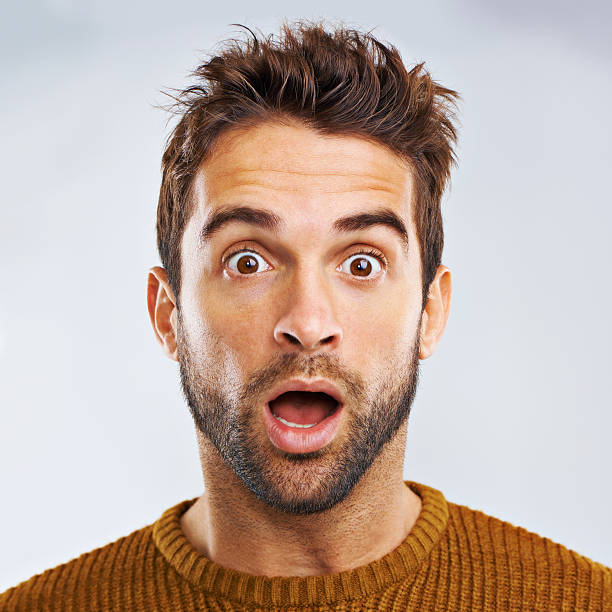 What just happened?? Portrait of a shocked young man against a gray background surprise stock pictures, royalty-free photos & images