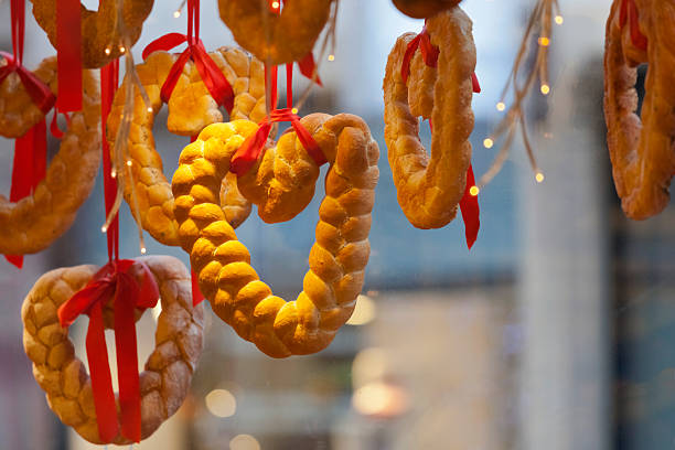 Seasonal heart shaped braided bread loaves hanging in an Alsace bakery window in in Strasbourg during Advent. Good dopy space.