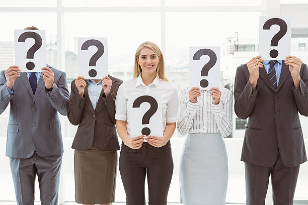 istock Business people holding question mark signs in office 522190057