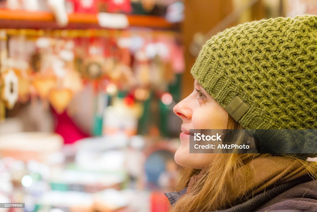 Marvelling at the wonders of the Christmas Market Young girl with a wool hat admires the magical Christmas Market in Colmar, France Profile View Stock Photo
