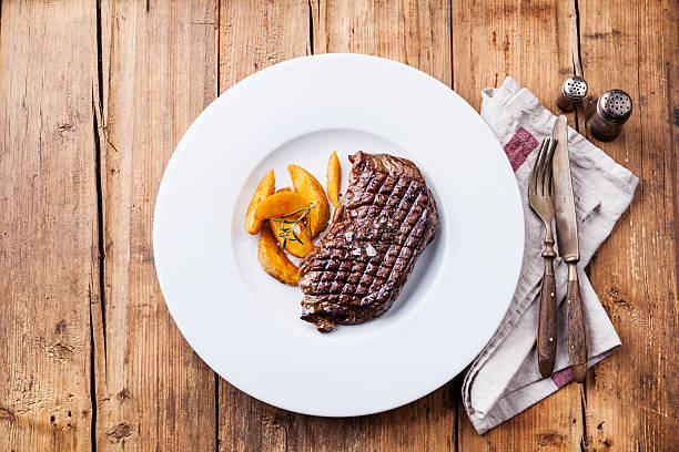 istock Grilled New York steak with potato wedges 522201451