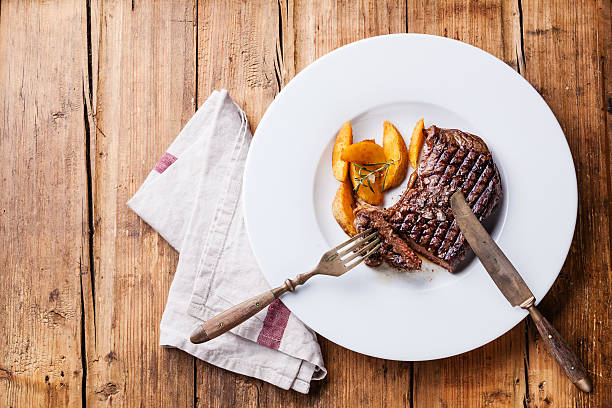 istock Grilled New York steak with potato wedges 522201455