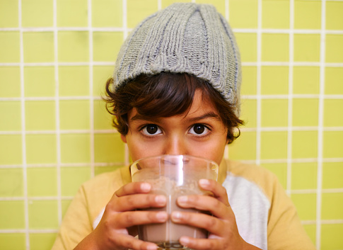 Shot of a cute little boy drinking a milkshake