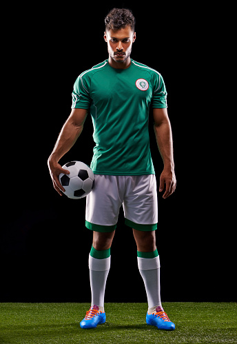 Full length studio shot of a handsome young soccer player isolated on black