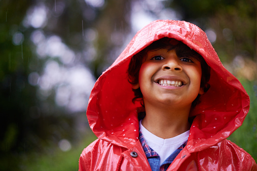 Shot of an enthusiastic little boy wearing a raincoat outside