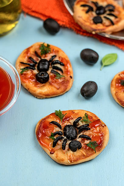 istock Mini pizzas with olives in shape of spider 522203449