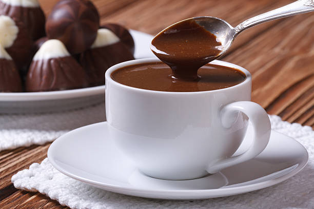 istock Spoon of chocolate being poured into a cup closeup 522204167