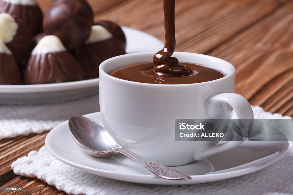 Chocolate is poured into a cup closeup on background sweets Chocolate is poured into a cup closeup on background sweets on the table Cup Stock Photo