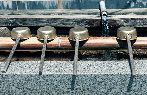 Ladles for dipping water for cleaning one's hands at Buddhist cemetery in Koyasan, Japan