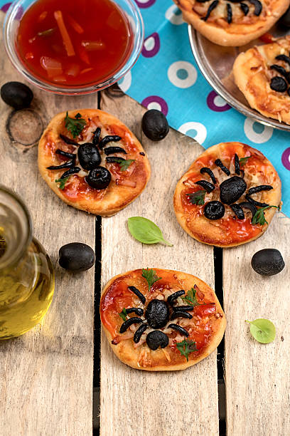 istock Mini pizzas with olives in shape of spider 522218363
