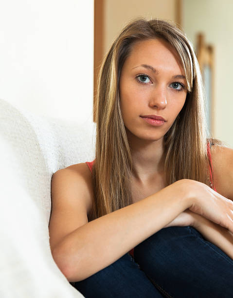 istock Sad girl sitting on couch 522218823