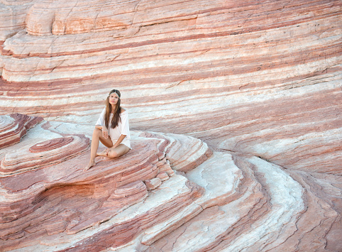 Beautiful woman relaxing in a hidden sand stone wave in Nevada. Nikon D810.