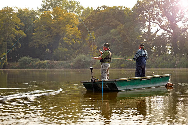 istock Two senior men fishing from a small boat 522222395