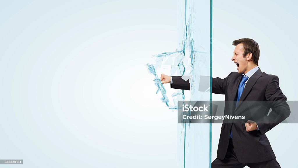 Man breaking glass Young determined businessman breaking glass with karate punch Adult Stock Photo