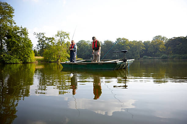 homens idosos pesca juntos no lago - fishing nautical vessel small men imagens e fotografias de stock