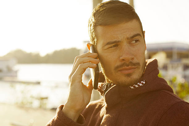 istock Handsome Man Talking On Mobile Phone At River Bank 522241935