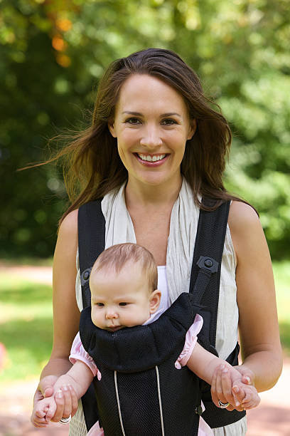 istock Smiling mother walking outdoors with baby 522244357