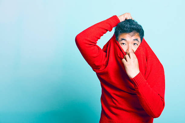 若いアジア人男性うと赤のセーター - 脱ぐ ストックフォトと画像