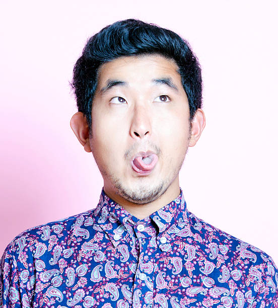 istock Young Geeky Asian Man in colorful shirt pulling funny face 522245887