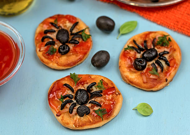 istock Mini pizzas with olives in shape of spider 522256495