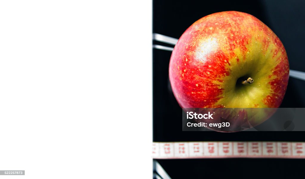 Dieting background The picture of a weight scale, measuring tape and red fresh apple.  Apple - Fruit Stock Photo