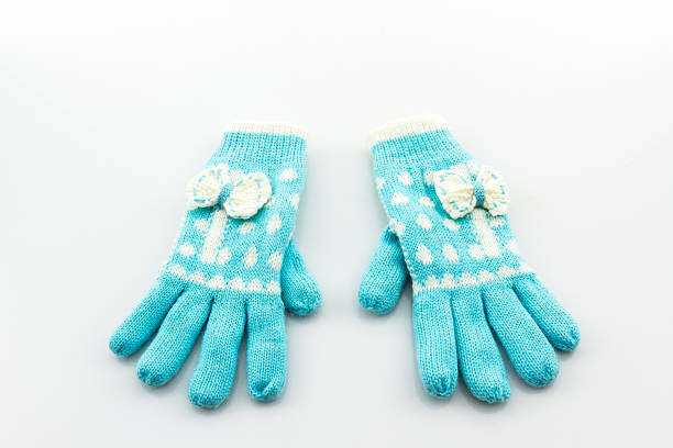 Two wool baby Christmas mittens decor on the old wooden planks background